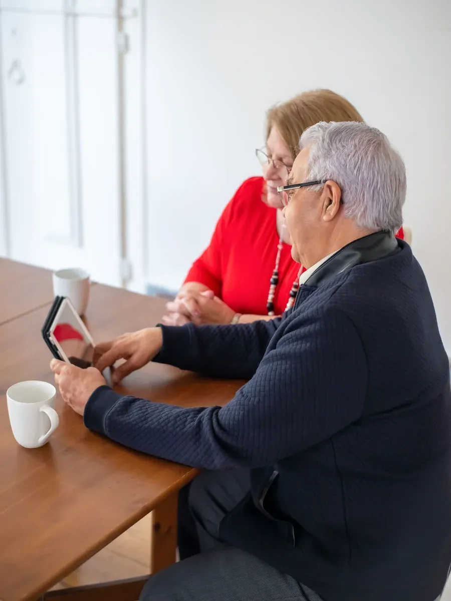 Older couple at home reading answers together